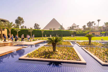 Swimming pool and park with Cheops pyramid in the background. Pyramids of Giza near Cairo, Egypt. Autumn 2018のeditorial素材