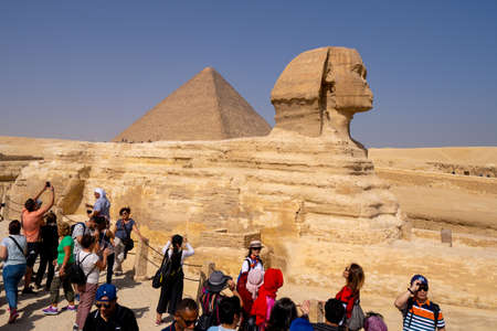 Tourists and Great Sphinx of Giza, with the Great Pyramid in the background. People take selfies. Cairo, autumn 2018のeditorial素材