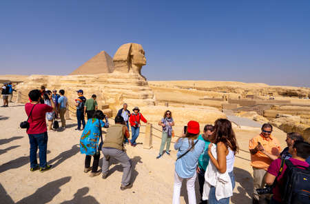 Tourists and Great Sphinx of Giza, with the Great Pyramid in the background. People take selfies. Cairo, autumn 2018のeditorial素材