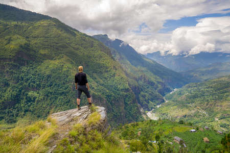 Man standing on top of the hill in Himalayas. Achievement and success. Trekking in Nepalの写真素材