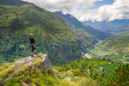 Man standing on top of the hill in Himalayas. Achievement and success. Trekking in Nepalの写真素材