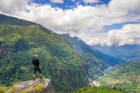 Man standing on top of the hill in Himalayas. Achievement and success. Trekking in Nepalの写真素材