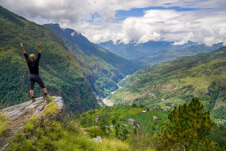 Man standing on top of the hill in Himalayas. Achievement and success. Trekking in Nepalの写真素材