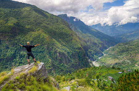 Man standing on top of the hill in Himalayas. Achievement and success. Trekking in Nepalの写真素材