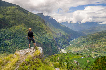 Man standing on top of the hill in Himalayas. Achievement and success. Trekking in Nepalの写真素材