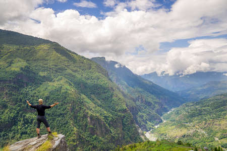 Man standing on top of the hill in Himalayas. Achievement and success. Trekking in Nepalの写真素材