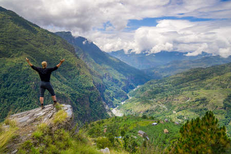 Man standing on top of the hill in Himalayas. Achievement and success. Trekking in Nepalの写真素材