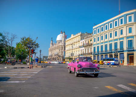 Retro car as taxi with tourists in Havana, Cuba. Captured near Gran Teatro de La Habana, El Capitolio and Paseo del Prado in spring 2019のeditorial素材