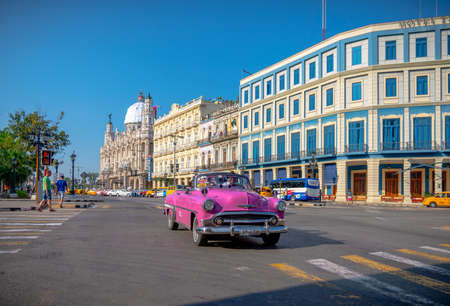 Retro car as taxi with tourists in Havana, Cuba. Captured near Gran Teatro de La Habana, El Capitolio and Paseo del Prado in spring 2019のeditorial素材