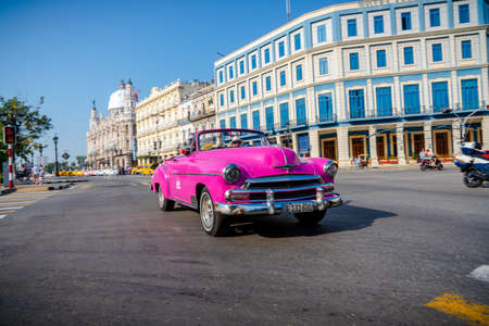 Retro car as taxi with tourists in Havana, Cuba. Captured near Gran Teatro de La Habana, El Capitolio and Paseo del Prado in spring 2019のeditorial素材
