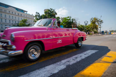 Retro car as taxi with tourists in Havana, Cuba. Captured near Gran Teatro de La Habana, El Capitolio and Paseo del Prado in spring 2019のeditorial素材
