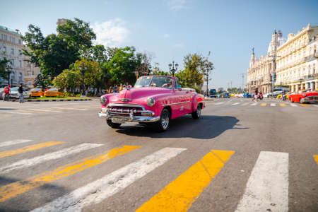 Retro car as taxi with tourists in Havana, Cuba. Captured near Gran Teatro de La Habana, El Capitolio and Paseo del Prado in spring 2019のeditorial素材