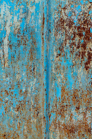 rust and damaged blue and yellow paint on metal sheet. Backgrounds and texturesの写真素材