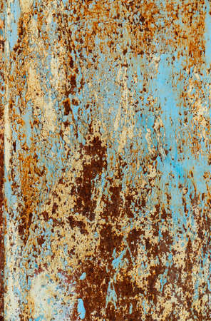 rust and damaged blue and yellow paint on metal sheet. Backgrounds and texturesの写真素材