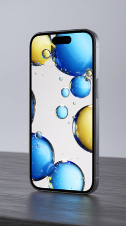 Close-up of a smartphone displaying a vibrant abstract design with blue and yellow bubbles.の素材