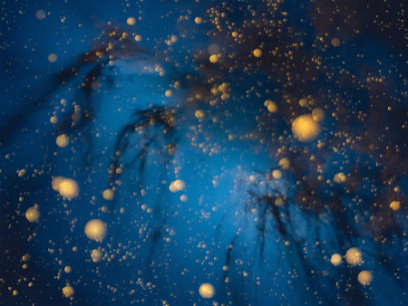 Abstract blue background with golden bokeh lights creating an ethereal atmosphere.の素材