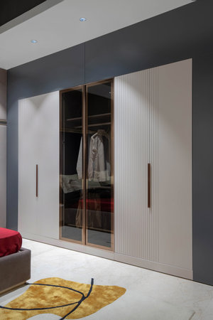 Interior of a modern bedroom with wardrobe and bed. Nobody inside