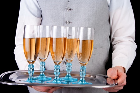 Male waiter serving champagne, black backgroundの写真素材