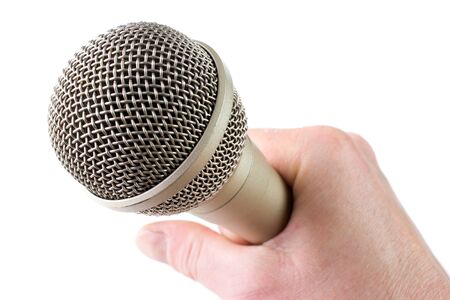 Audio microphone in hand, isolated on whiteの写真素材
