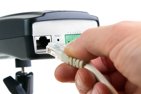 Hand inserting ethernet cable into network cameraの写真素材