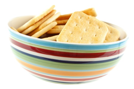 Saltine cracker snacks in bowl , isolated on whiteの写真素材