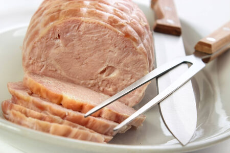 Cooked turkey breast roll on plate with carving setの写真素材