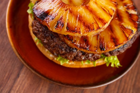 Burger with grilled pineapple on dish , shallow dofの写真素材