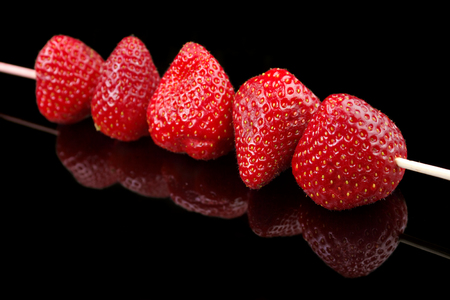 Group of fresh strawberries in skewer stick , black backgroundの写真素材