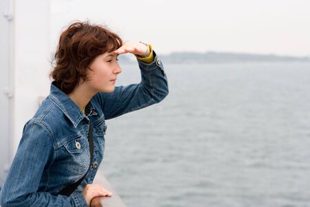 Young girl aboard the ship looks in a distanceの写真素材