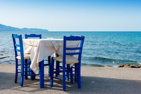 Table and chairs in sidewalk cafe at Kissamos, Crete, Greeceの写真素材