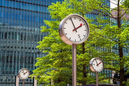 Clocks and skyscrapers in Canary Wharf, financial district at London. Englandのeditorial素材