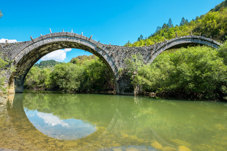 Three arches stone bridge of Kalogeriko (or Plakida) on the river of Voidomatis, near the villages of Kipi and Koukouli in the Central Zagori. Greeceの写真素材