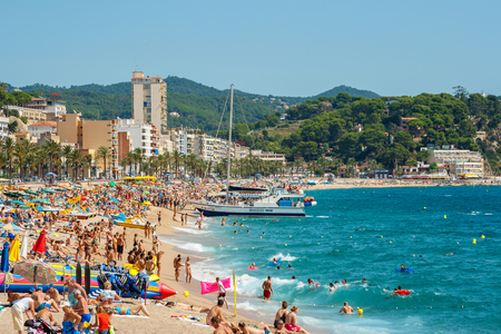 LLORET DE MAR, SPAIN - SEPTEMBER 12, 2007: Many people relaxing and sunbathing on sandy beachのeditorial素材