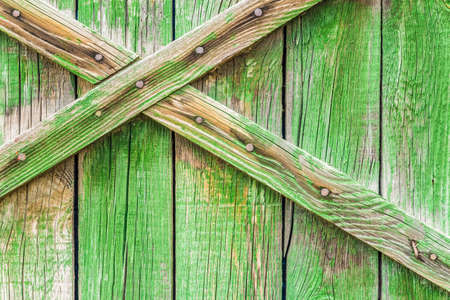Old boards painted green. Structure of old boards. Old gate with boards.