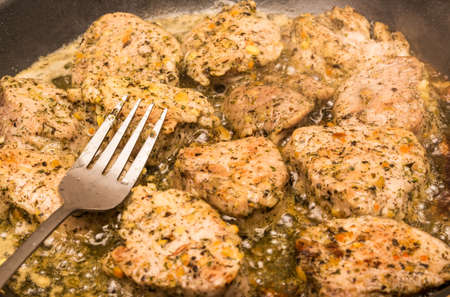 Frying meat and fork. Meat in spices fried in sauce. Preparing the dish. Frying meat. Beef fried in a pan.の写真素材