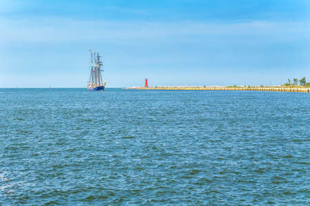 Sailboat entering the bay. Landscape with horizon, water and yacht.の写真素材