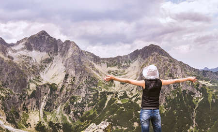 Tatra mountains in Slovakia. Mountain landscape with a woman enjoying the summit. Mountain landscapes in the Tatras.の写真素材