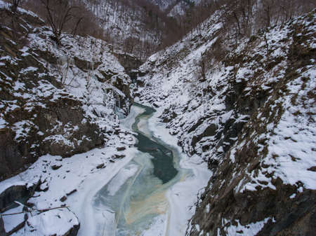 Aerial Photos. Frozen mountain river in granite gorge.の写真素材