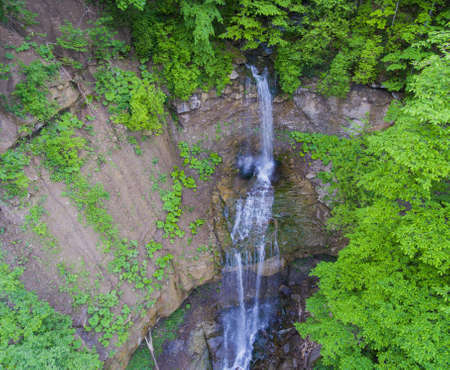 Long the flow of the waterfall cascading from the cliff. Aerial view. Drone photo.の写真素材