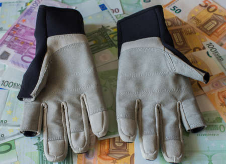 Gloves for sailing against the background of Euro banknotes. Selective focus.