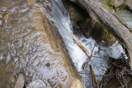 Mountain stream is blocked with logs. Selective focus.