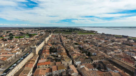 Medieval stone fortified fortress town Aigues-Mortes in France. Aerial view of tiled roofs and stone...