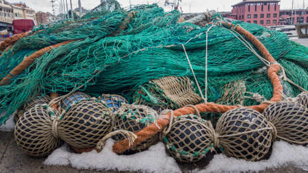 Fishing net with floats folded on the shore for winter storage.