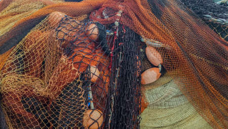 Orange and black fishing nets with floats.
