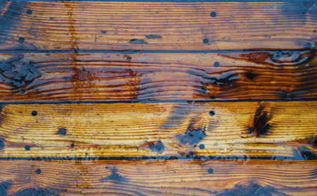 The texture on the wet planks of the wooden pine deck.