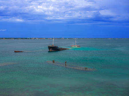 Cargo ship and barges stranded near the shore.