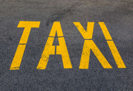 The yellow word TAXI on the pavement.の写真素材