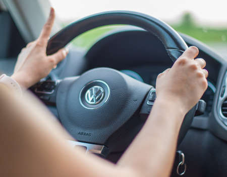 KRASNODAR, RUSSIA - MAY 22, 2018: Women's hands on the steering wheel of the car Volkswagen. Selective focus.のeditorial素材