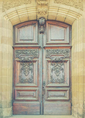Old wooden gate with carved patterns. Toned picture.