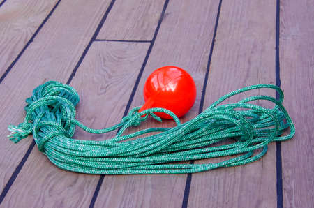 Sea tackle to facilitate the supply of the mooring cable to the shore. A coil of thin green rope...